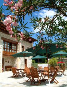 un grupo de mesas y sillas con sombrillas en Hotel Aldama Golf, en Quintana de Llanes