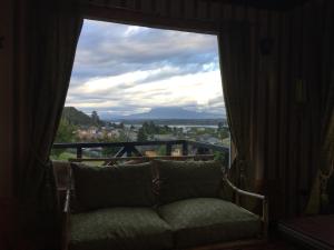 a couch sitting in front of a large window at Cabaña Hagemann in Puerto Varas