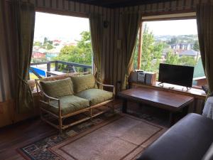 a living room with a couch and a table and a television at Cabaña Hagemann in Puerto Varas