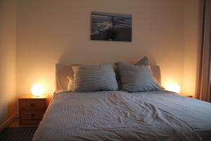 a bedroom with a bed with two lamps on it at Ferienwohnung Charlotte in Karlshagen