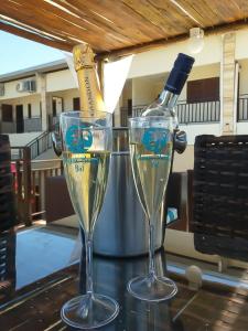 zwei Gläser Champagner und eine Flasche auf dem Tisch. in der Unterkunft Muriú Beach Flat in Muriú