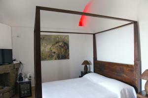 a bedroom with a canopy bed and a painting on the wall at Don Mario Resort in Pantelleria