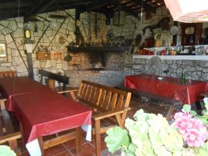 a dining room with a table and chairs and a stone wall at Apartamentos Carolina in Celorio