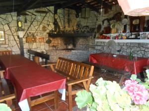 comedor con mesa, sillas y pared de piedra en Apartamentos Carolina, en Celorio