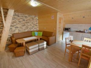 a kitchen with a couch and a table in a room at Domek nad Lasem in Koniaków