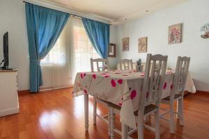 comedor con mesa y sillas con cortinas azules en Giardino dei Colori Appartamenti Dianella Pool relax &family friendly, en Toscolano Maderno