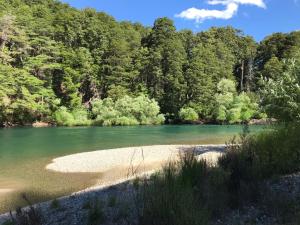 ein Wasserkörper mit Bäumen im Hintergrund in der Unterkunft Posada del Angel in San Carlos de Bariloche