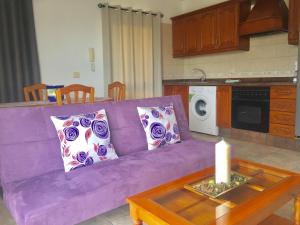ロス・ジャノス・デ・アリダネにあるApartamentos los Llanos de Aridaneの紫色のソファ、テーブルの上にキャンドルが置かれたキッチン