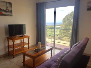 sala de estar con sofá, TV y ventana en Apartamentos los Llanos de Aridane, en Los Llanos de Aridane