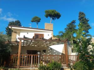 ein weißes Haus mit einem Holztor und Bäumen in der Unterkunft Casa Francesca La Valle di Erice in Valderice