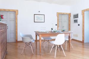 uma sala de jantar com uma mesa de madeira e cadeiras brancas em Terrazza su Assisi Guest House em Perugia