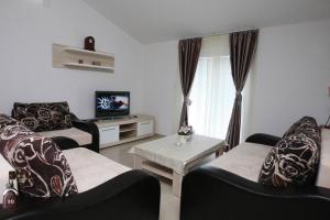 een woonkamer met 2 stoelen en een televisie bij Villa Andjelina in Budva