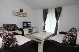 a living room with two chairs and a tv at Villa Andjelina in Budva