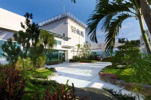 a building with a palm tree in front of it at Yuh Tong Hotel in Chiayi City