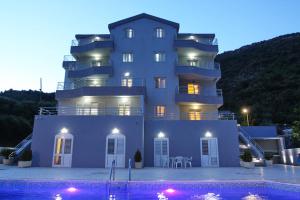 a large building with a pool in front of it at Villa Andjelina in Budva