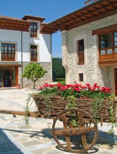a wooden planter with red flowers in a building at Hotel Aldama Golf in Quintana de Llanes +37 photos