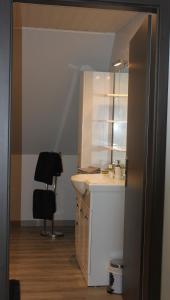 a bathroom with a sink and a mirror at CHEZ SANDRINE in Surbourg