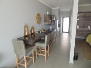 a kitchen with a table and chairs in a room at Apartment 32, BAY VIEW SUITES in Langstrand