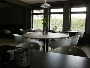 a dining room with tables and chairs and windows at Quarante Cinq in Evergem