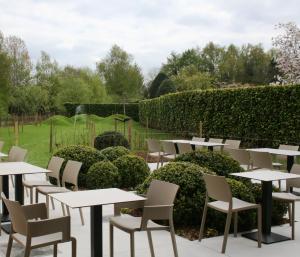 una fila de mesas y sillas en un jardín en Quarante Cinq, en Evergem