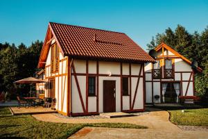 een klein huis met een bruin dak bij Kubiczówka in Kopalino