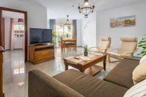 uma sala de estar com um sofá e uma televisão em SF Carihuela Luxury Suite em Torremolinos