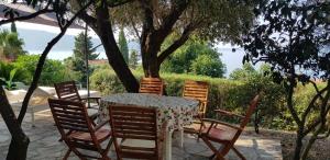 una mesa y sillas sentadas bajo un árbol en Zora Holiday Home, en Herceg-Novi