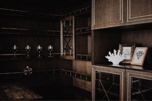 a dark room with a shelf with wine glasses at AJ - tér apartman miskolc in Miskolc