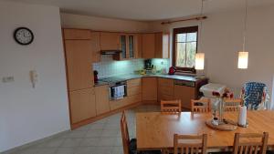 a kitchen and dining room with a wooden table at Villa Park Lipno 206 in Lipno nad Vltavou
