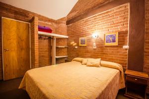 a bedroom with a large bed in a brick wall at Balcón del Diquecito in Villa Carlos Paz