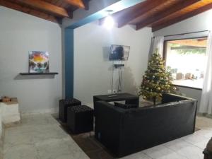 una sala de estar con un árbol de Navidad en la esquina en La Morera de Ángel en Tafí del Valle