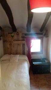 a bedroom with a bed and a window and a red lamp at El Bricial in Bezas +7 photos
