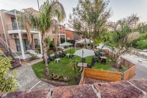 an outdoor patio with tables and chairs and an umbrella at Balcón del Diquecito in Villa Carlos Paz