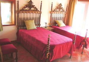 1 dormitorio con 2 camas con sábanas rojas y manta roja en Villa Barq, en Barcelos