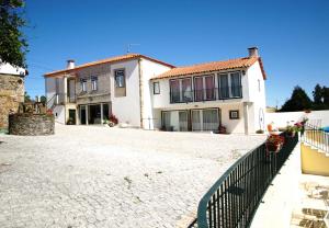 une grande maison avec une clôture devant elle dans l'établissement Villa Barq, à Barcelos