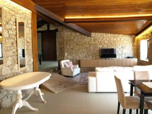 a living room with a table and a stone wall at Villa Sole in Vila do Conde