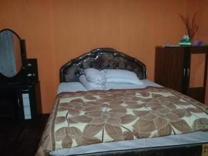 una camera con letto e copriletto floreale di Nusa Nalan Beach Resort a Rumah Olat