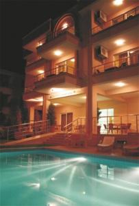 a large apartment building with a swimming pool at night at Zeytin Apart Hotel in Cesme