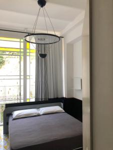 a bedroom with a bed and a chandelier at PrimoPianoPosillipo in Naples