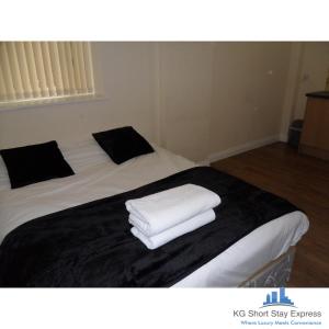 a bed with white towels on top of it at KG Short Stay Express Luxury Apartments in Leicester