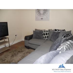 a living room with a couch and a tv at KG Short Stay Express Luxury Apartments in Leicester