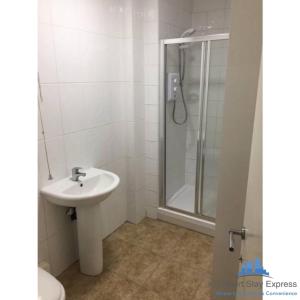 a white bathroom with a sink and a shower at KG Short Stay Express Luxury Apartments in Leicester