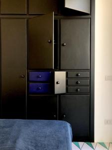 a bedroom with black cabinets and a blue bed at PrimoPianoPosillipo in Naples