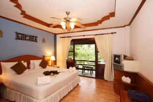 a bedroom with a bed with a ceiling fan at Salad Beach Resort - SHA Extra Plus in Salad Beach