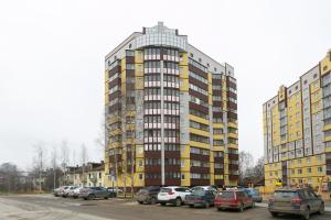 ヴォログダにあるХочу приехать на Гагарина 14 и Детский переулок 7の駐車場に車を停めた高層ビル