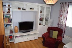 a living room with a tv and a chair at Teach Barney in Falcarragh