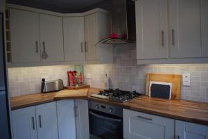 een keuken met witte kasten en een fornuis met oven bij Teach Barney in Falcarragh