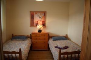 een slaapkamer met 2 bedden en een lamp op een dressoir bij Teach Barney in Falcarragh