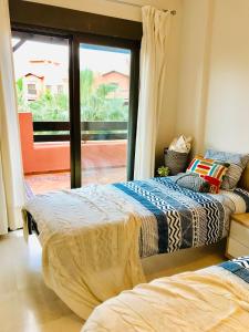 two beds in a room with a sliding glass door at Sunny Apartment Tropical Coast,Granada. Calle Rector Pascual Rivas Carrera in Motril