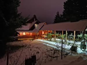 una casa nella neve di notte di Guesthouse Ramović a Zlatibor